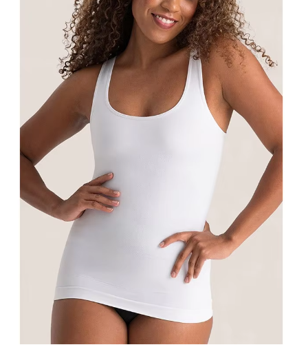 Woman wearing a white tank top against a plain background